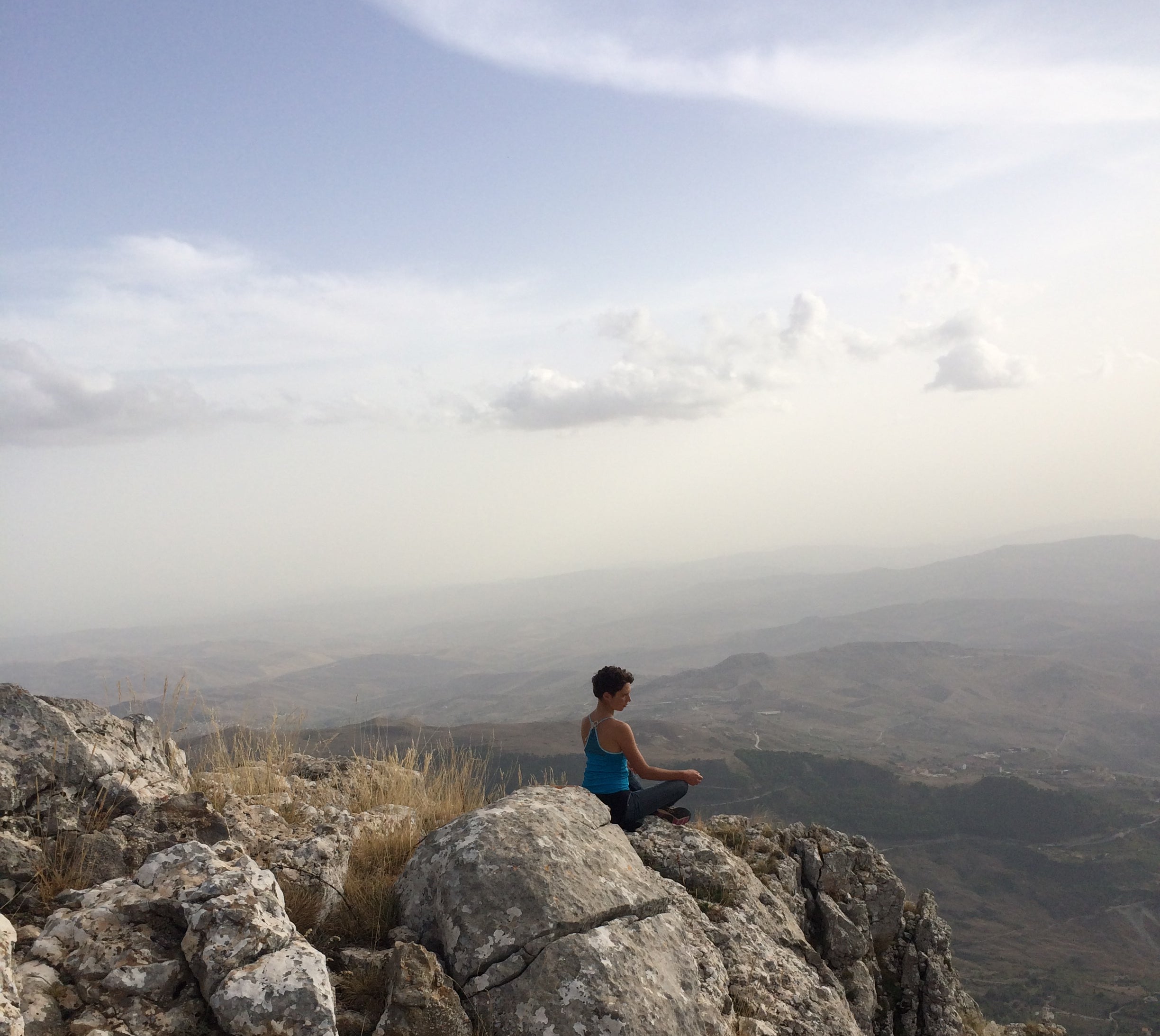 Mountain meditation break on Qunafa Sicily cycling tour — rocky cliff misty mountain views