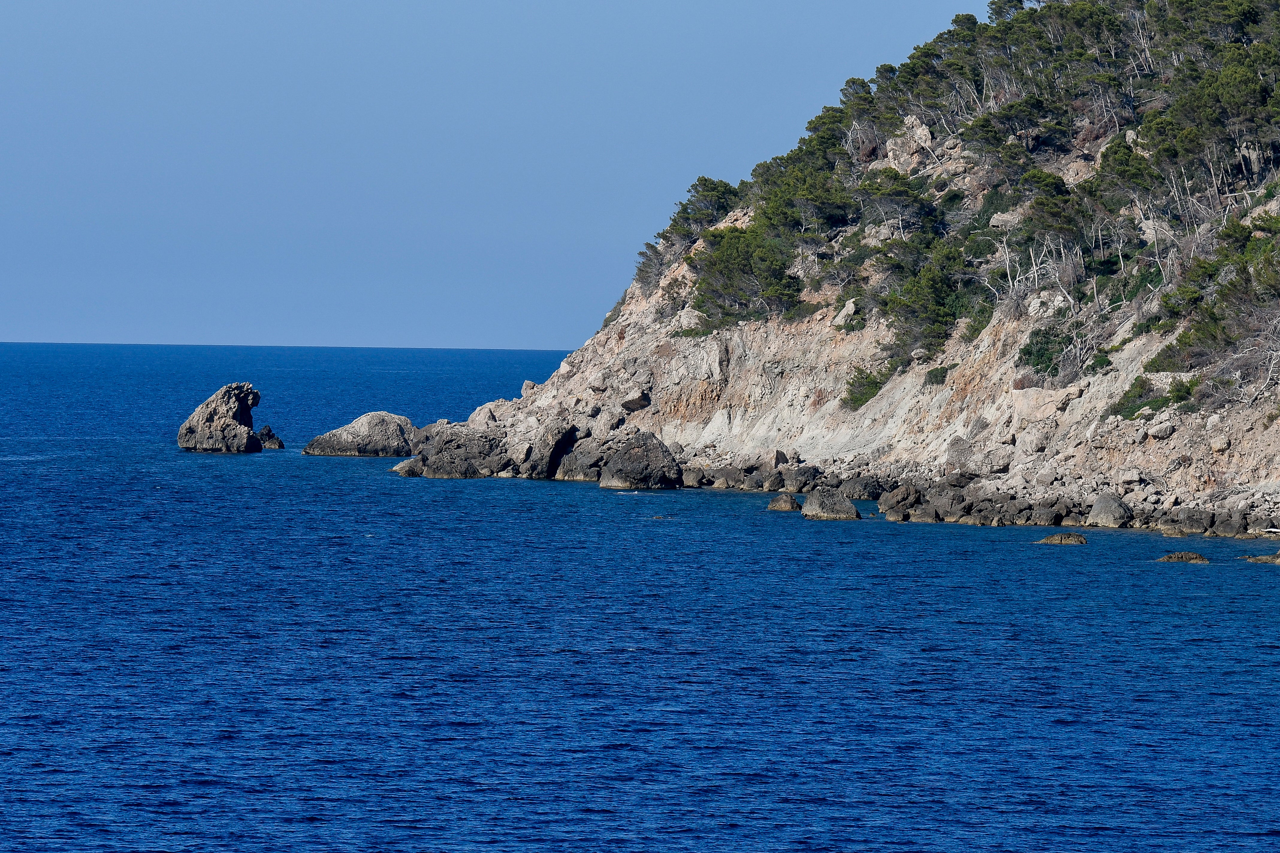 Premium Mallorca cycling tour — cyclist riding coastal road at golden hour Spain