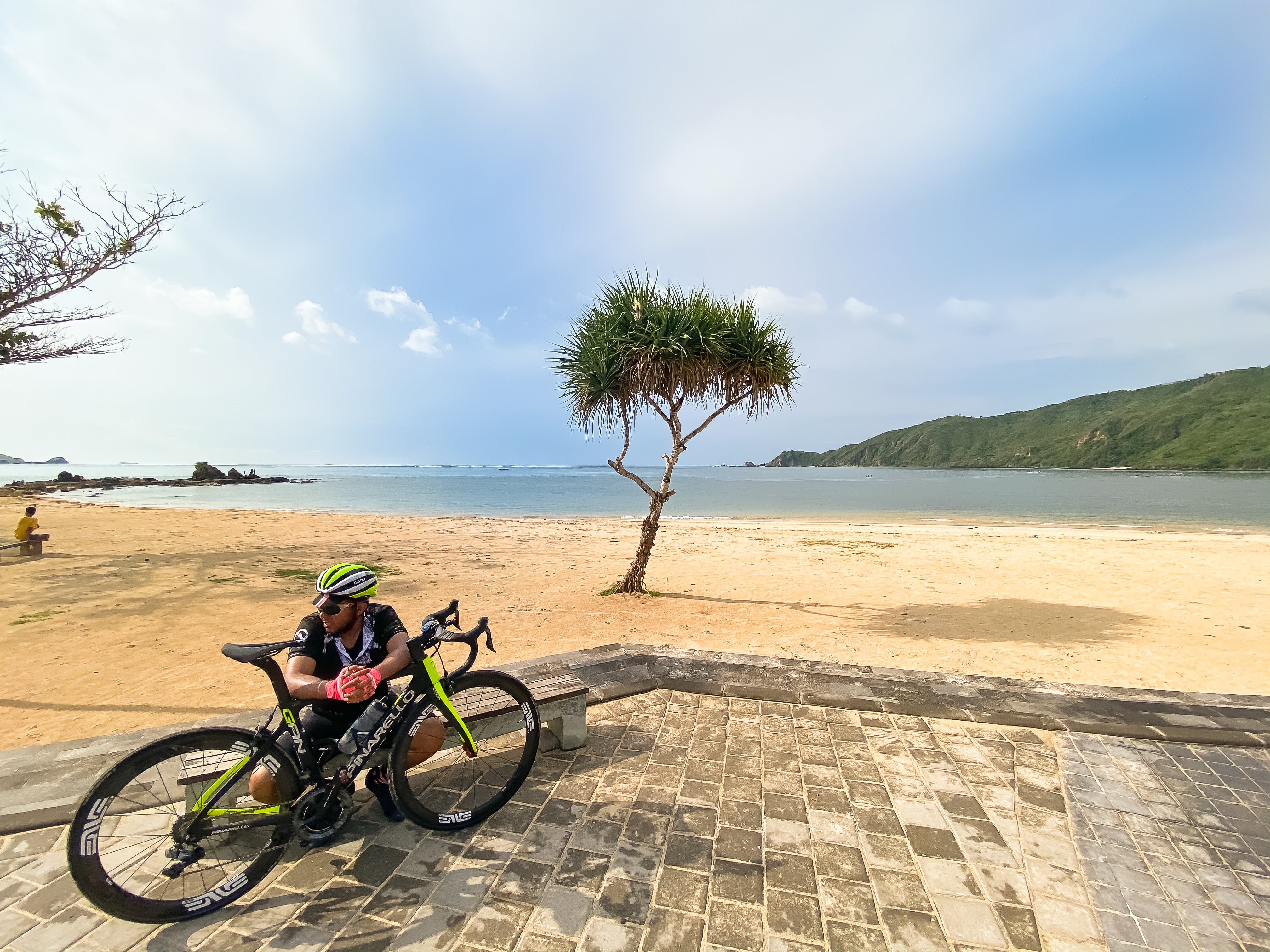 Sunset ride finish in Lombok — Qunafa cyclists celebrating at beachside with bikes silhouetted